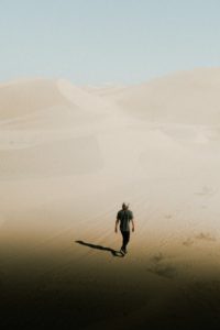 photo of person walking on desert